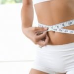 A woman measuring her waist